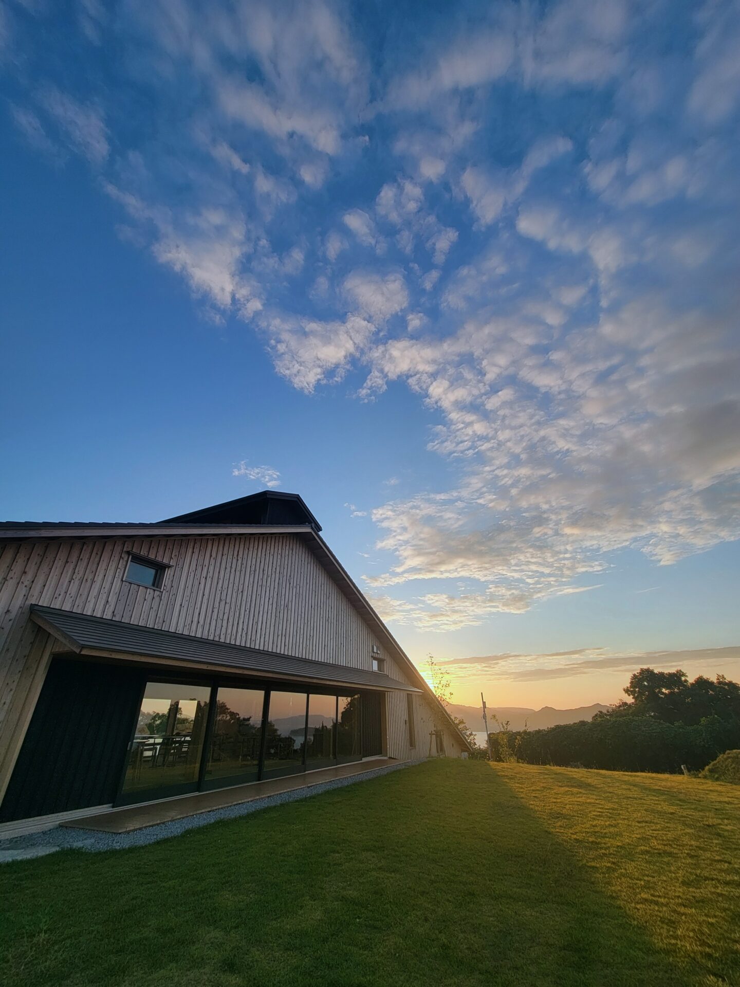 「時の納屋」の建物と日暮れの空