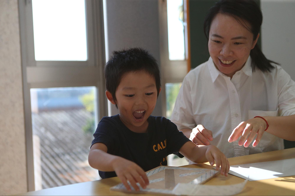 黒板作りをする母親と子ども