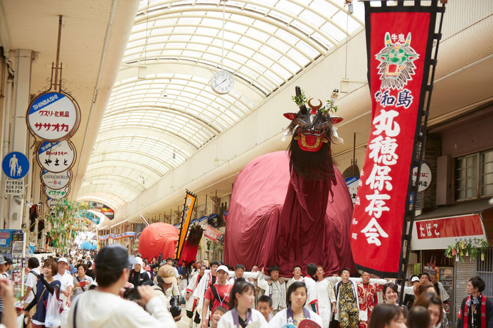 担ぎ手が巨大な牛鬼を担ぐうわじま牛鬼まつりの一場面