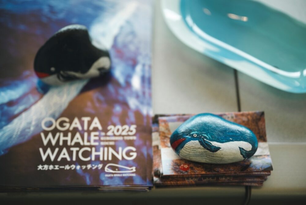 高知・大方ホエールウォッチングのロゴとクジラの置物