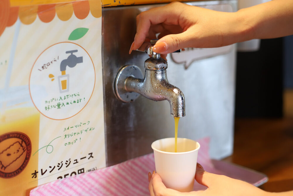 蛇口からみかんジュースを注ぐ様子