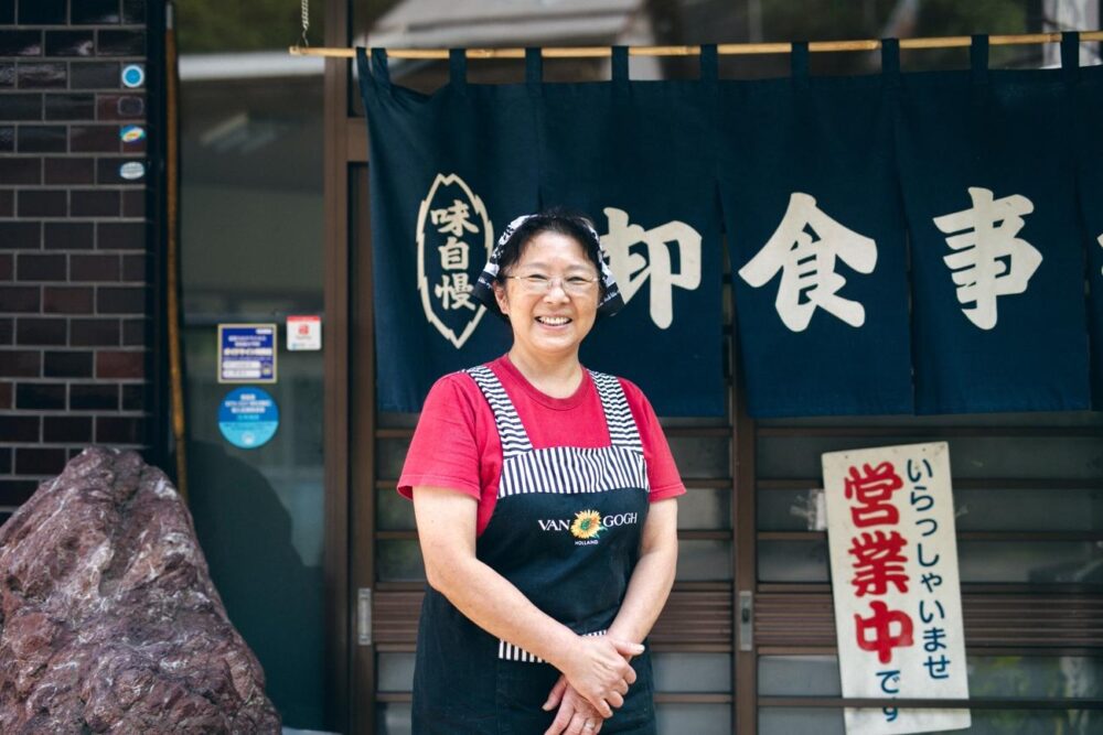 谷口食堂のスタッフさんと店ののれん