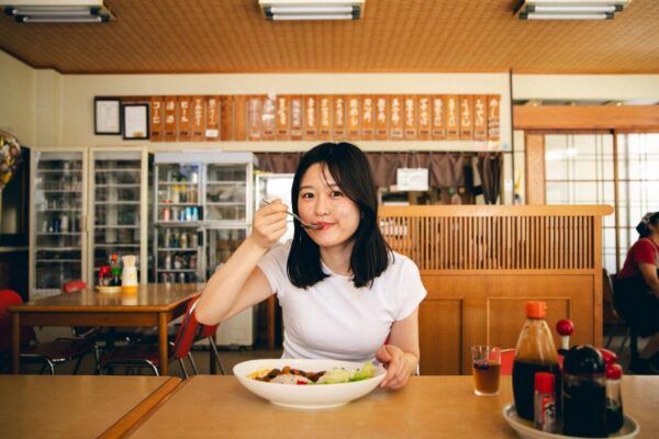 谷口食堂の鹿カレーをほおばる女性