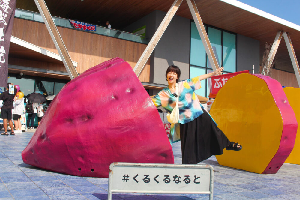 鳴門金時のオブジェでポーズをとる藤間さん