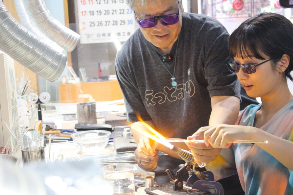 ガラス玉の制作体験をする藤間さん