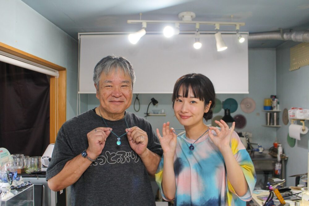 完成したガラス玉と記念撮影をする藤間さん