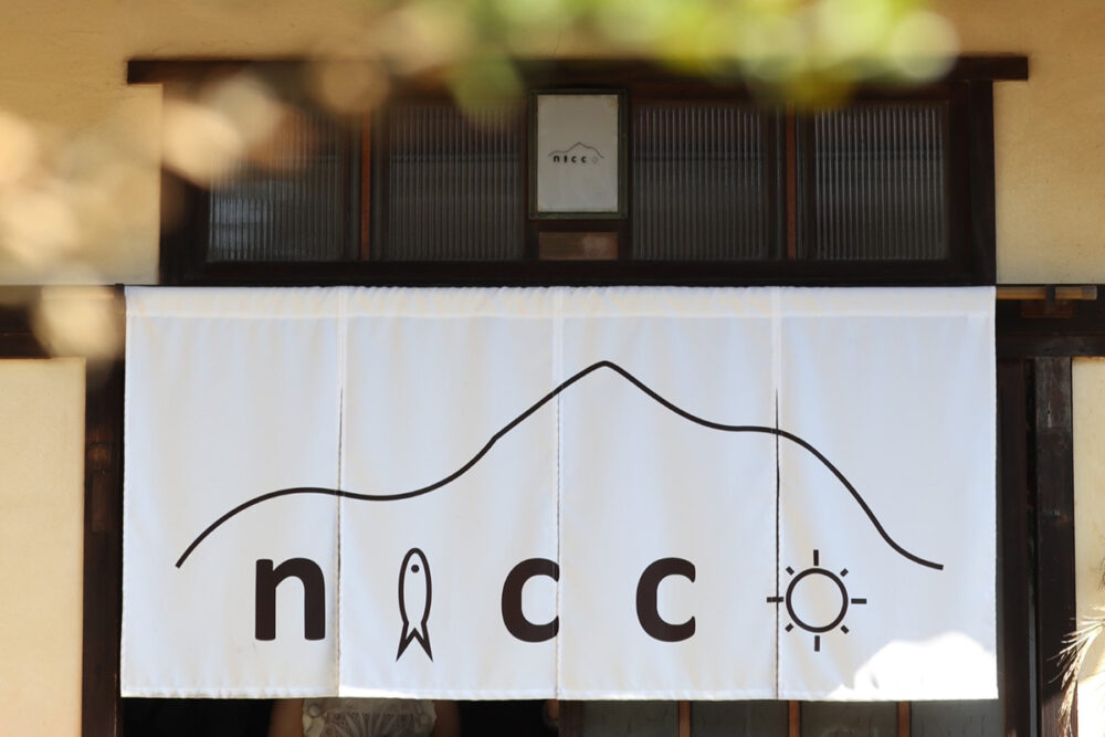 niccoの目印となっている、店名と九島のモチーフがすてきな白いのれん