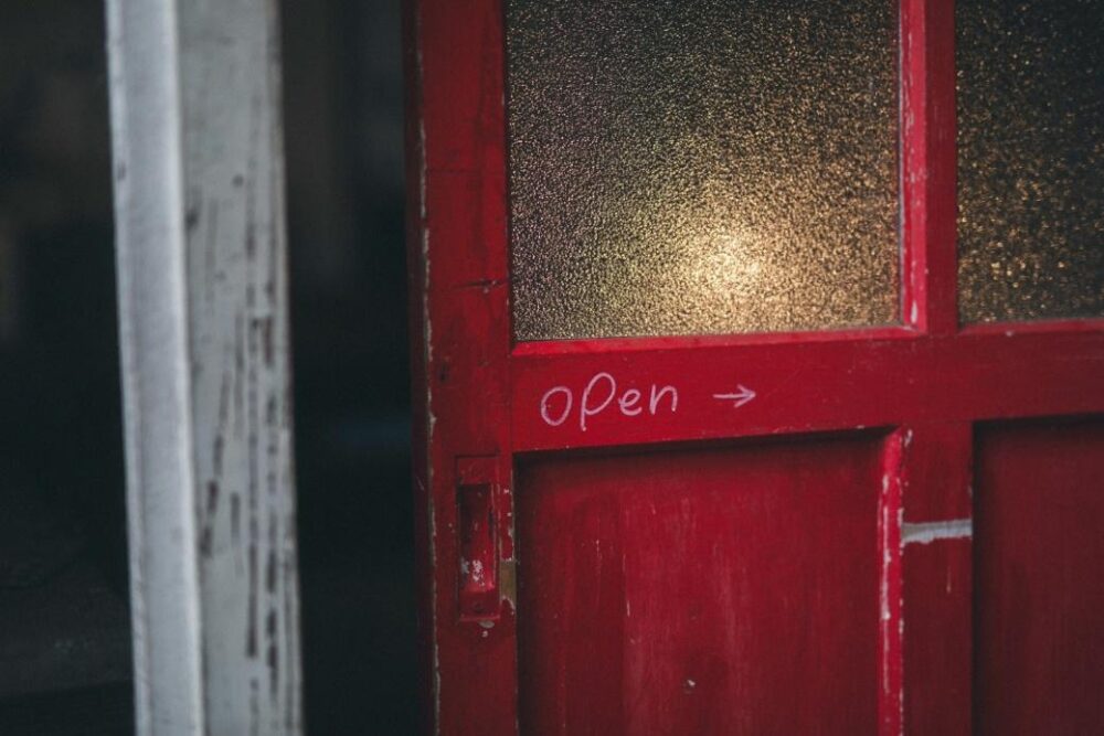 DIYした赤い扉に手書きの「Open」