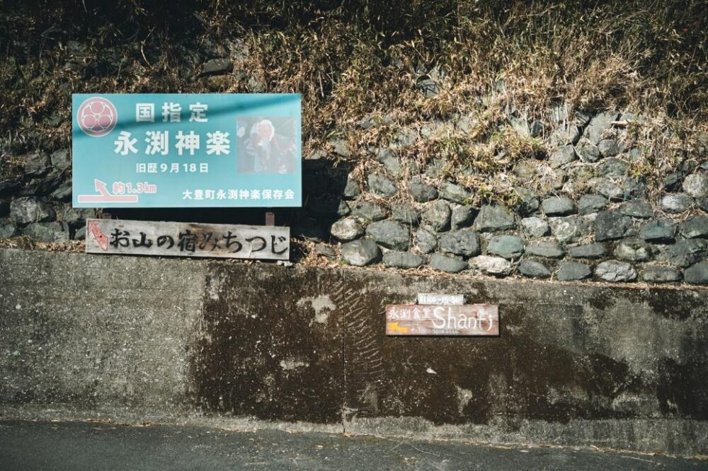 永渕神社の看板の隣に永渕食堂シャンティの看板