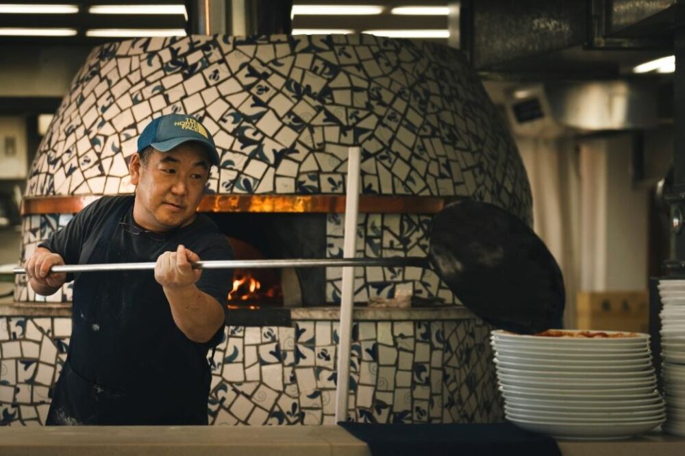 アズリッシモの職人が香ばしい香りとともに焼きたての本格ピッツァを提供