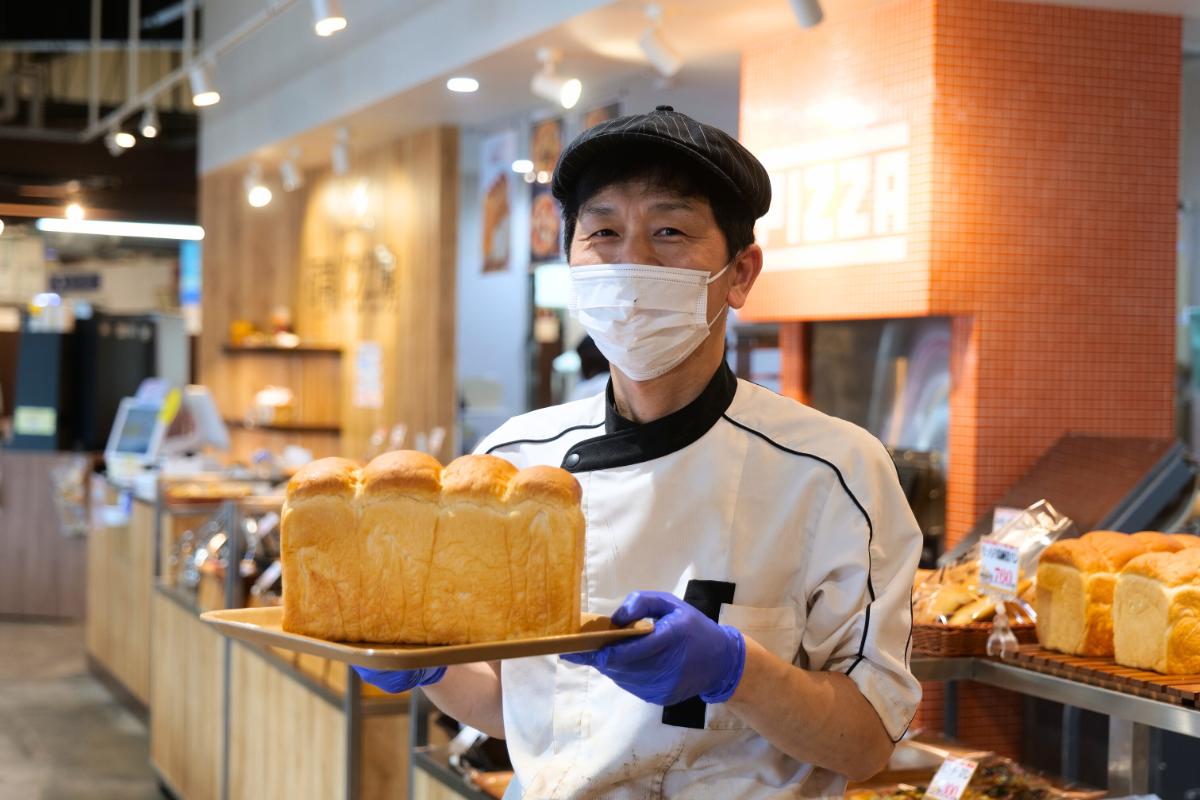 もっちり湯種食パンを持つ石窯パン工房の店員さん