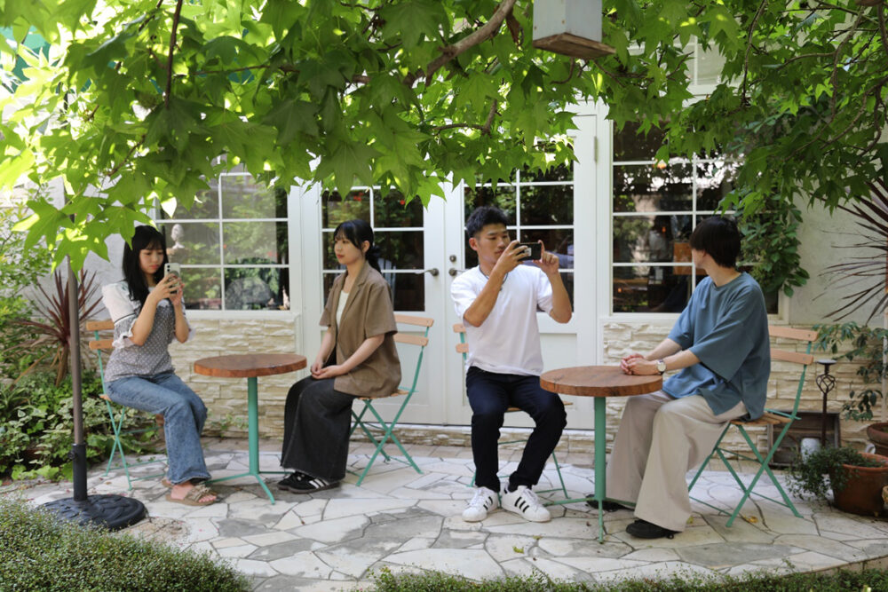 Cafe A littleのテラス席に座って撮影する学生たち