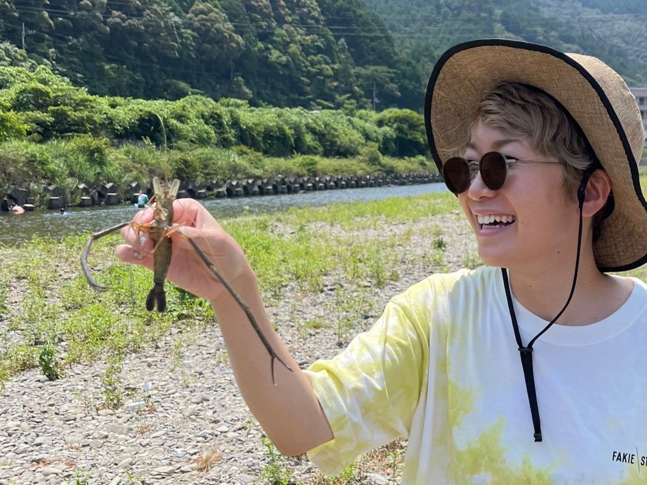 川でエビを手にする福岡晃子さん