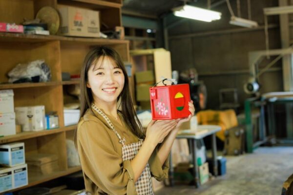 江淵鏡台店の絵付け体験で完成した遊山箱を手に持つ女性