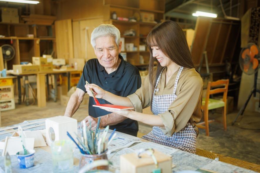 遊山箱の絵付け体験で指導する江淵鏡台店の江淵達人さん