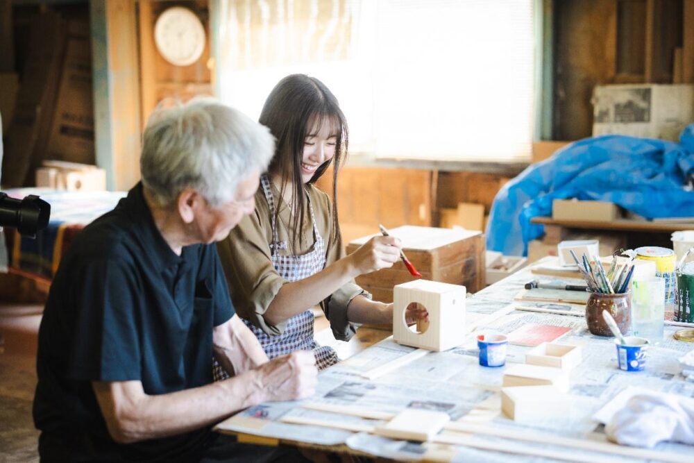 遊山箱の絵付け体験で指導する江淵鏡台店の江淵達人さん