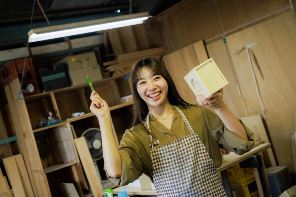 江淵鏡台店で遊山箱の絵付け体験をする女性