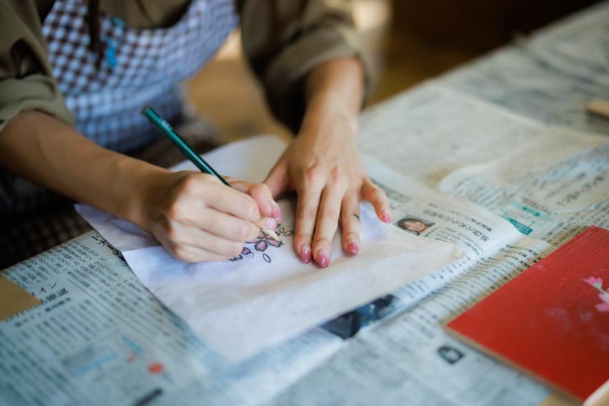 遊山箱の絵付けで、トレーシングペーパーで型紙から転写する工程