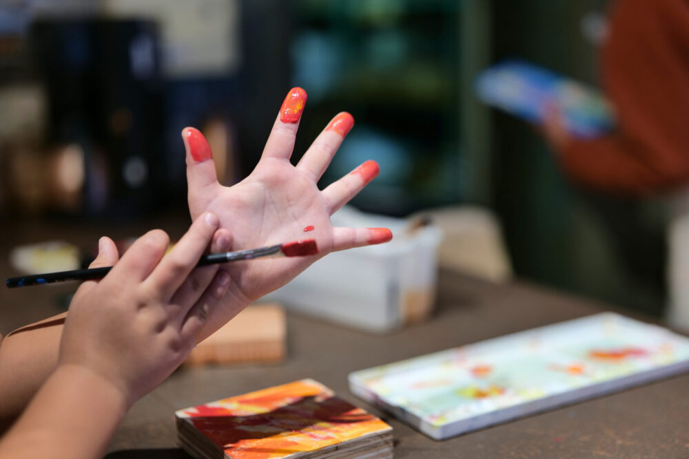 手を汚しながらも木材に絵を描いて楽しむ様子