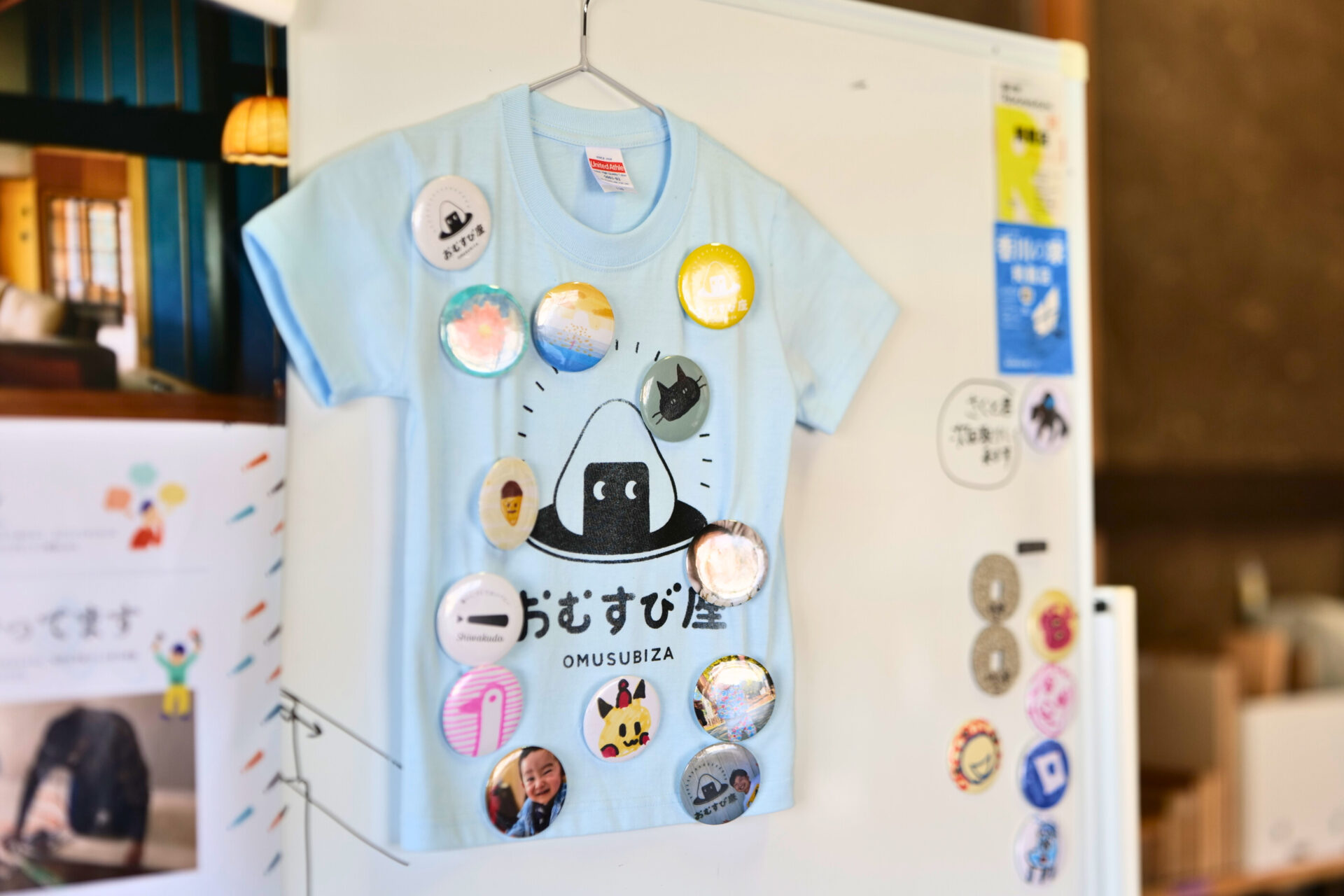 平日限定ランチ利用で作れる缶バッジを付けた「おむすび座」のTシャツ