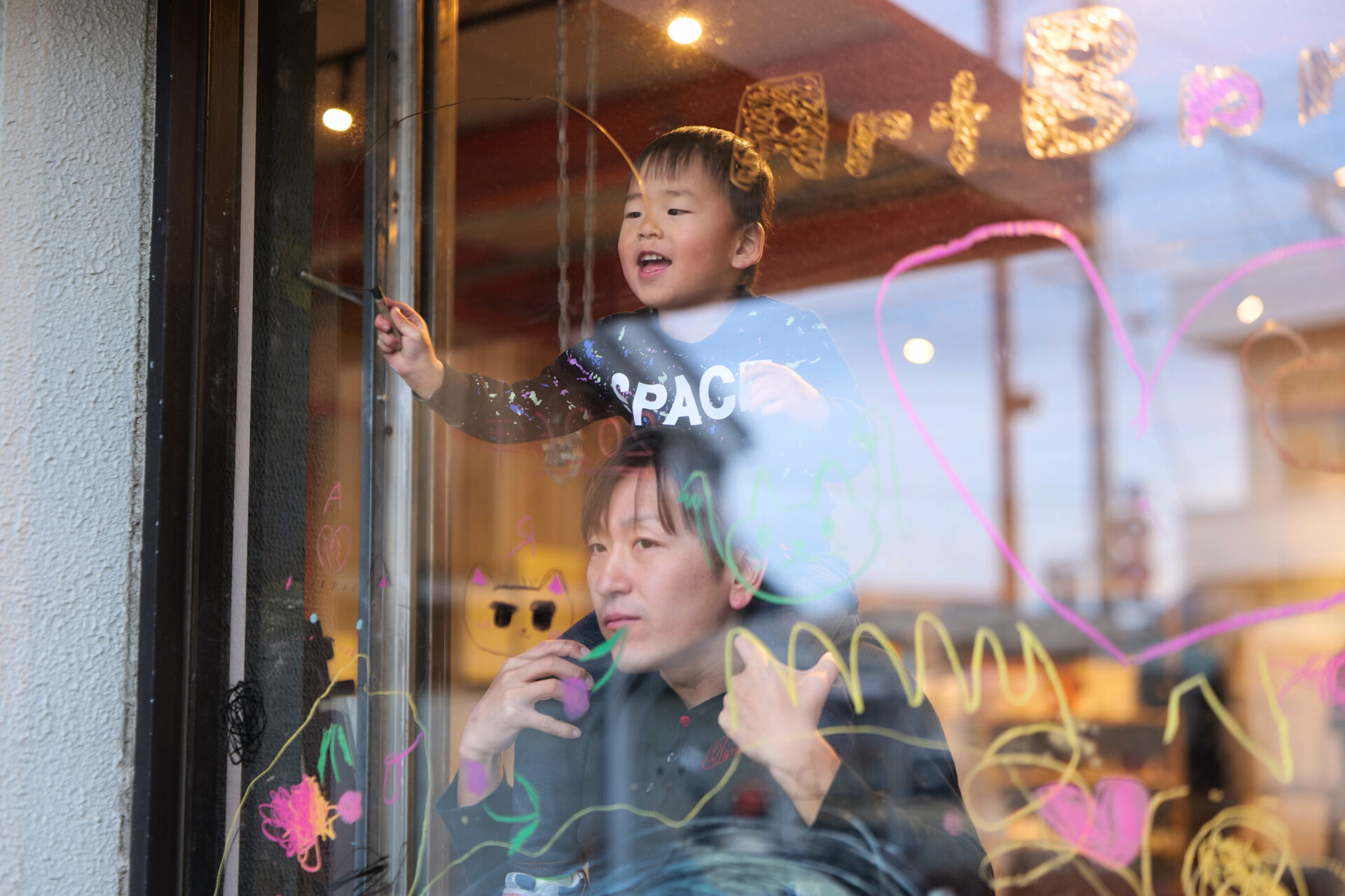 ガラス窓にカラーコンテで絵を描くさぬきよファミリー